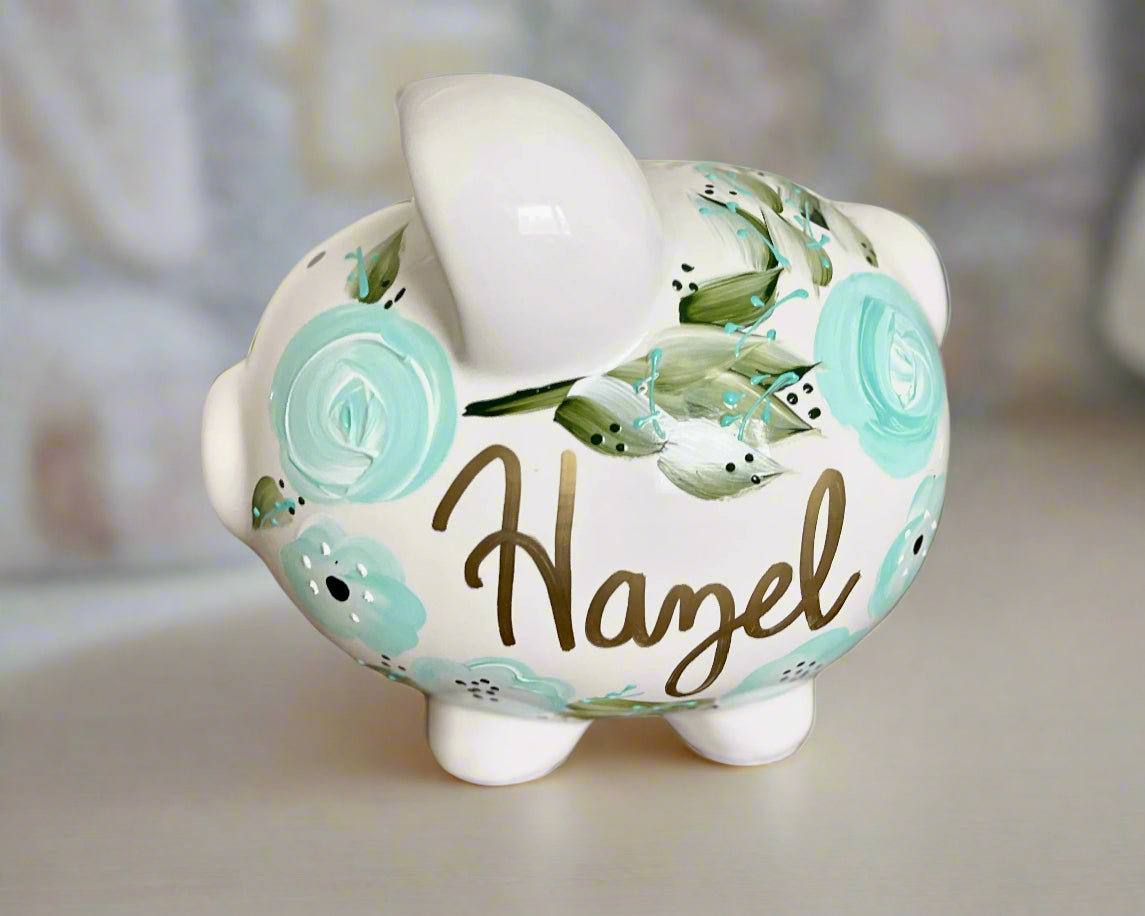 Custom hand-painted piggy bank with teal floral design and personalized