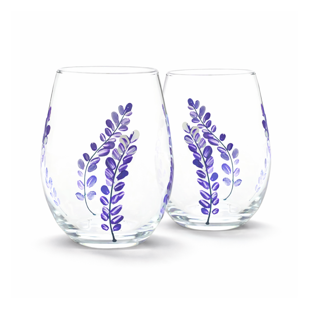 Two clear stemless wine glasses with purple leaf designs on a white background