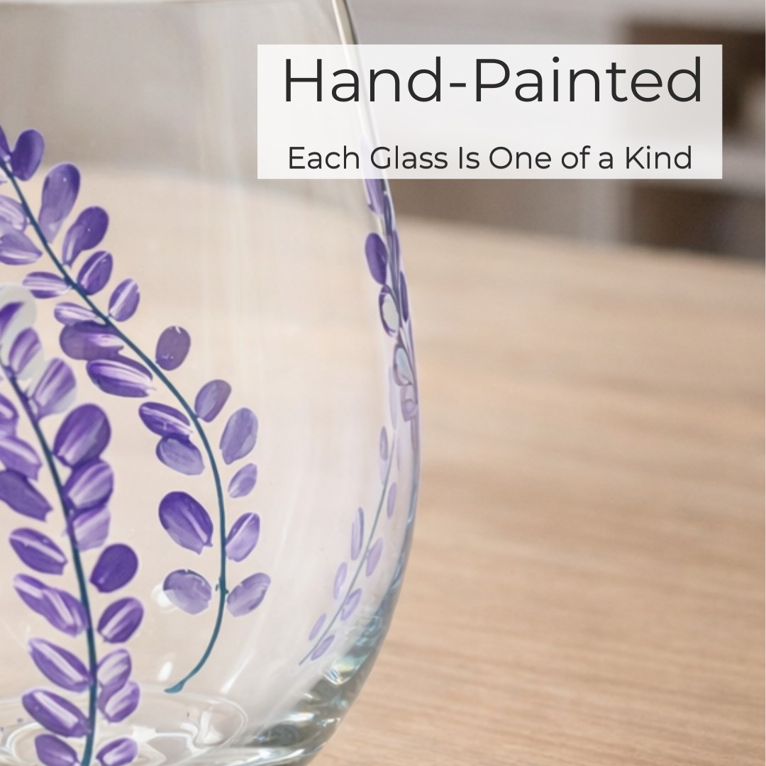 Hand-painted glass with purple floral design on a wooden surface