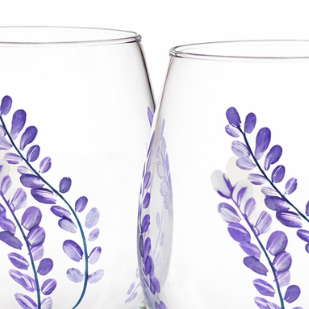 Two clear glasses with purple floral designs on a white background