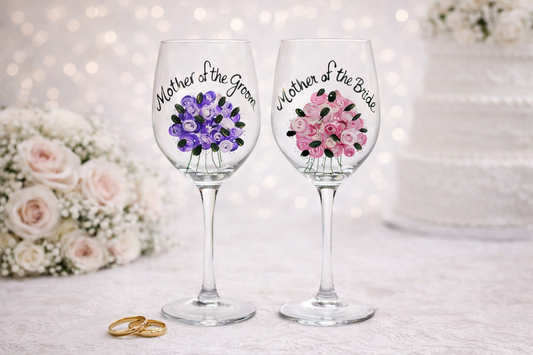 Two wine glasses with floral designs and text mother of the bride and mother of the groom 