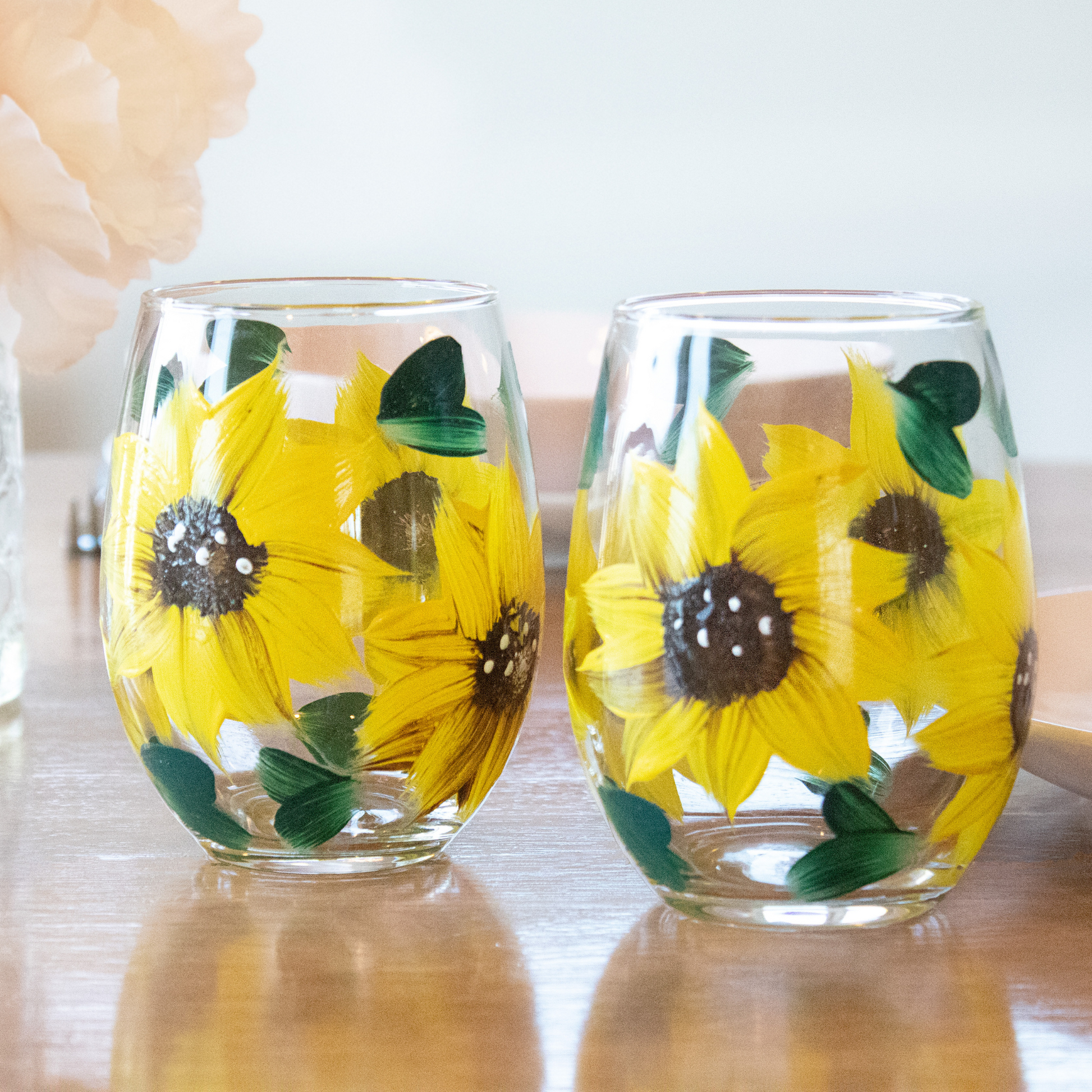 Hand-painted sunflower stemless wine glass in a rustic farmhouse setting