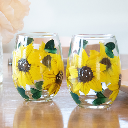 Hand-painted sunflower stemless wine glass in a rustic farmhouse setting